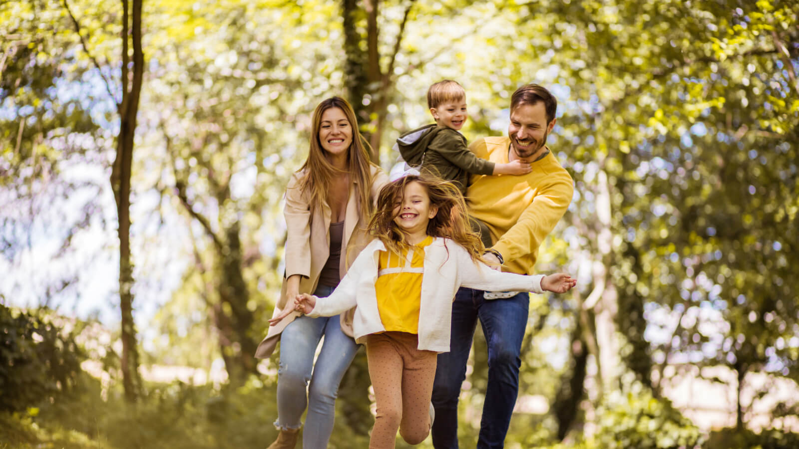 family of four smiling while walking outdoors