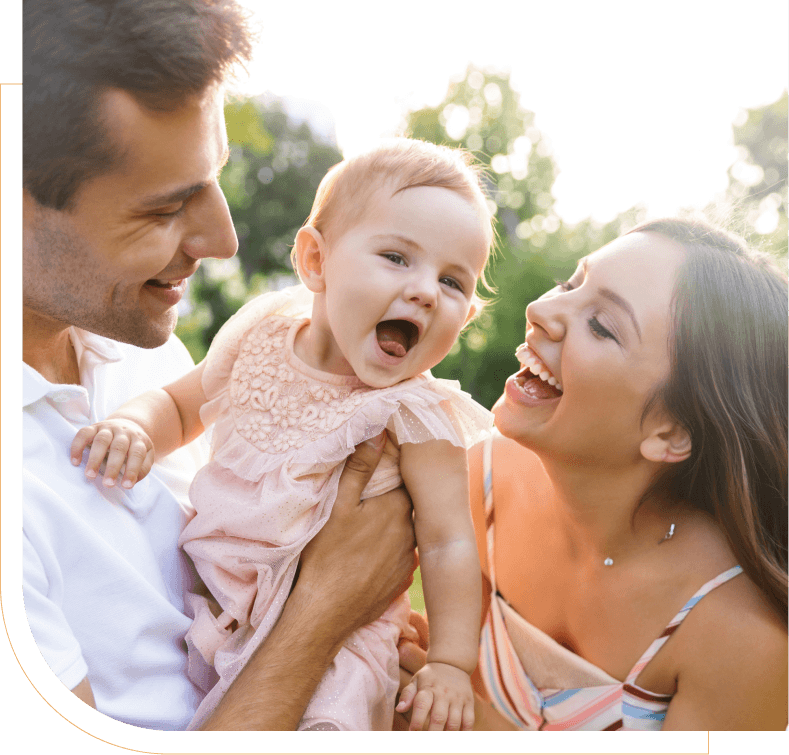 mom and dad smiling at happy baby