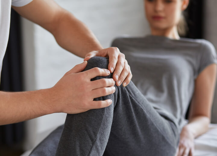 Chiropractor adjusting woman's knee