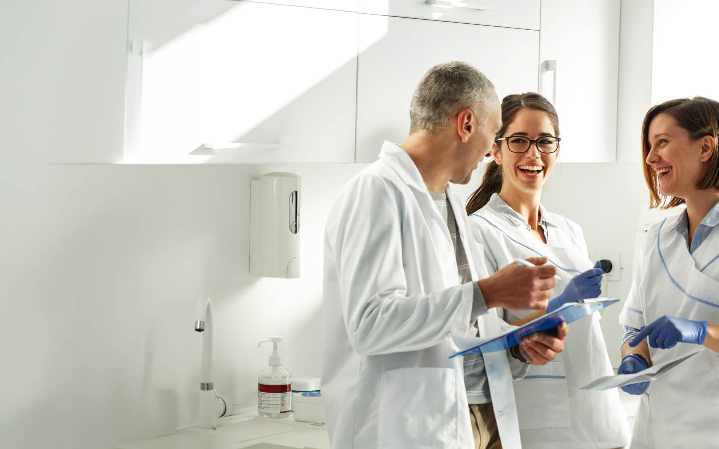 team of people in dentists coats smiling