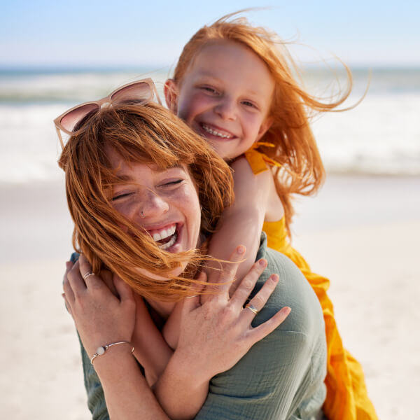 smiling mom with daughter riding on her back