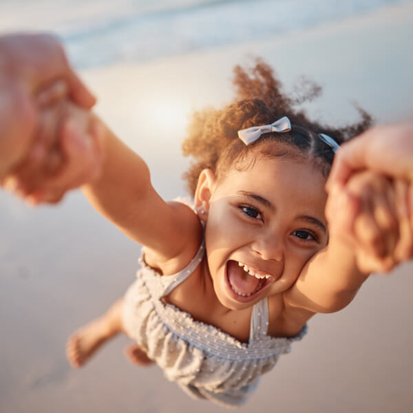 smiling kid being spun around by a parent