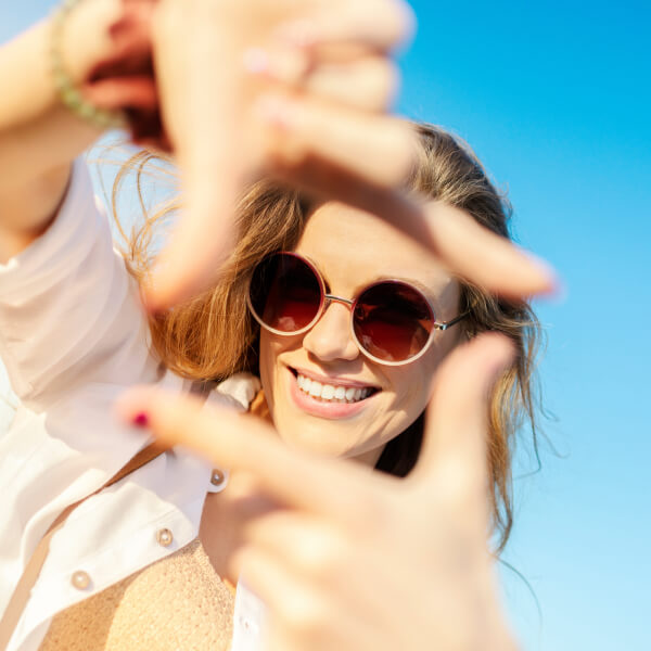 woman framing her face in a square with her hands