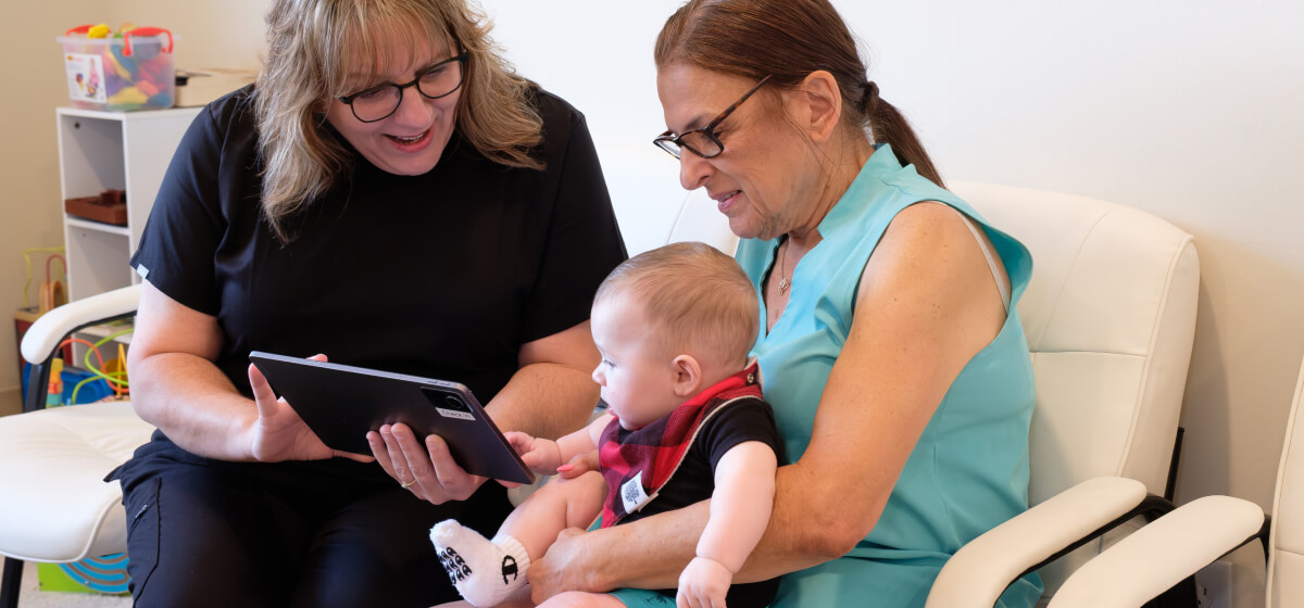 Hershey chiropractor talking to a patient holding a baby