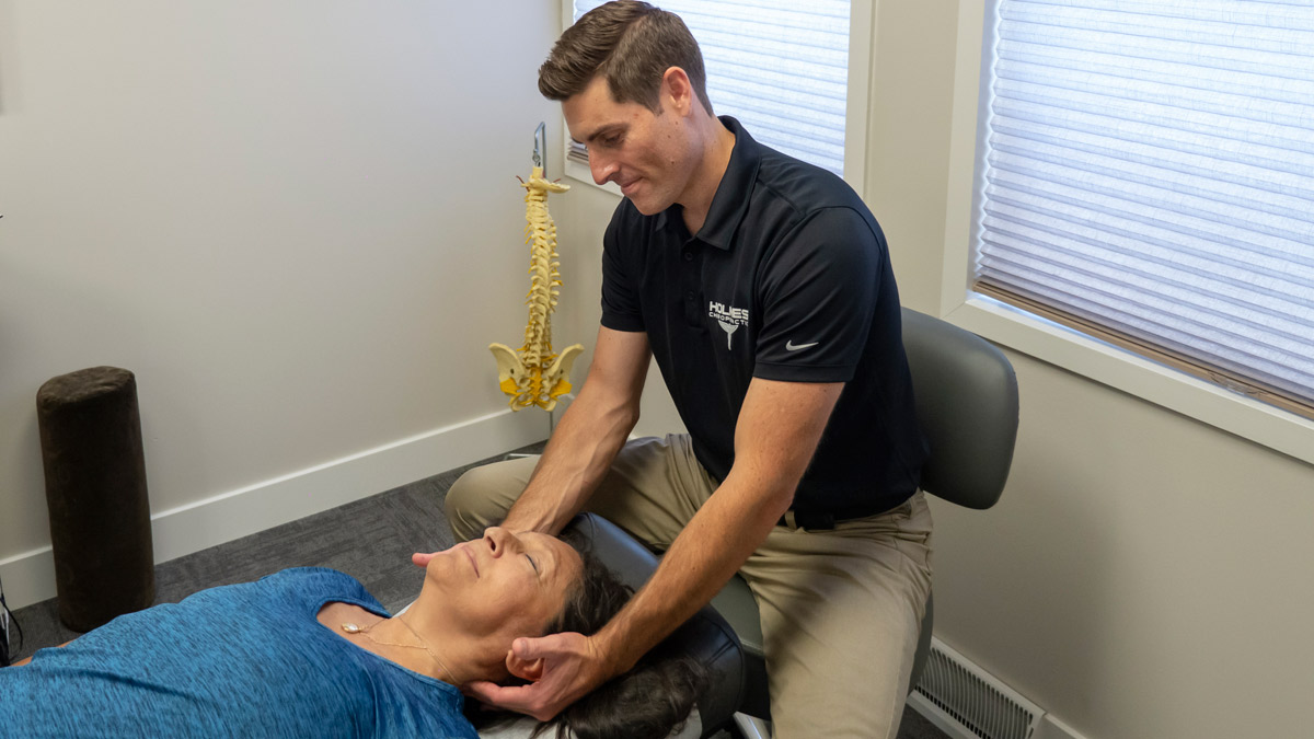 Dr Brandon Holmes adjusting patients neck