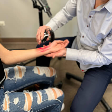 South Elgin Chiropractor using laser therapy to treat patient's arm