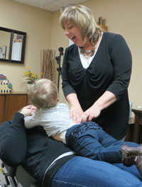 Jenny Gieger, Waterford Chiropractor, adjusts mom and baby