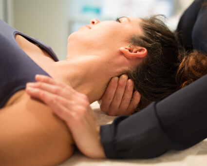 Female chiropractor adjusting patient's neck