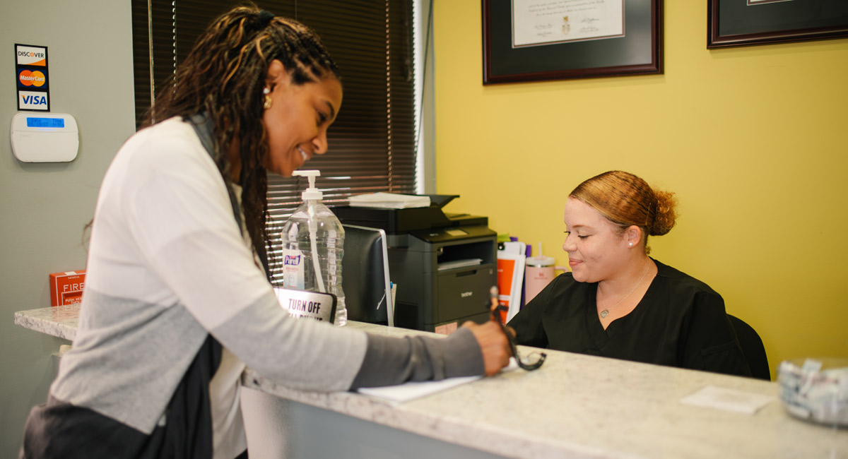 Happy patient filling out forms at reception