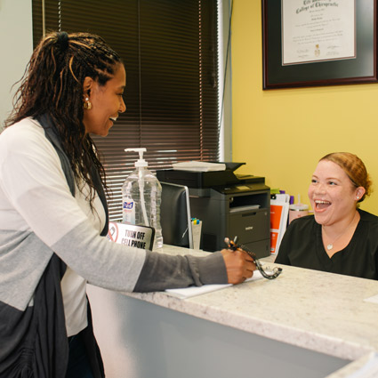 Receptionist and patient laughing together