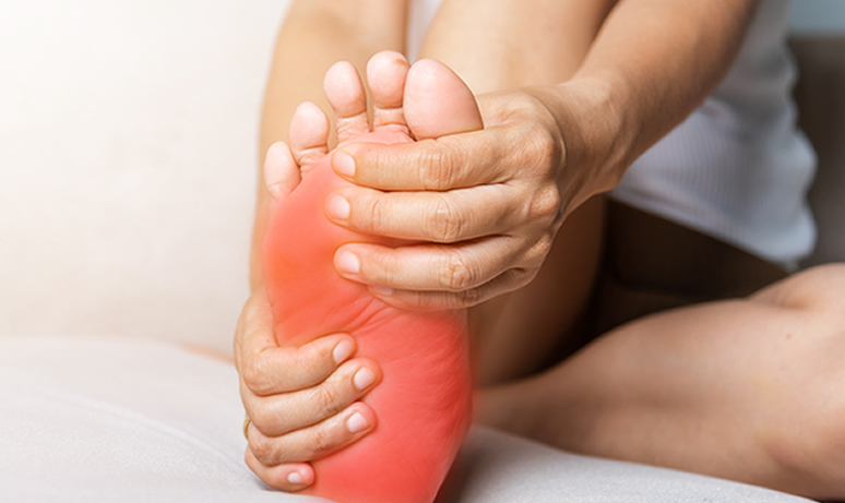 closeup of woman holding foot in pain