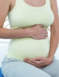 Pregnant woman holding her stomach