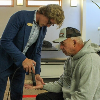 patient having shockwave therapy treatment on hand