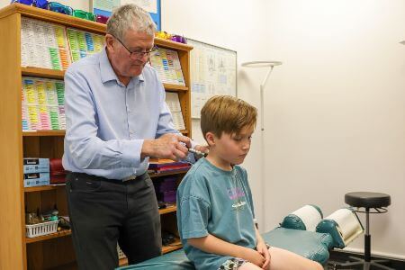 Hamilton chiropractor using activator technique to adjust a child