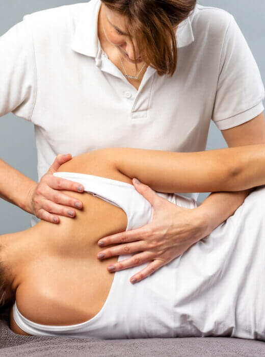 doctor adjusting the upper-back of a female patient
