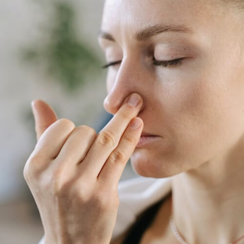Woman holding her nose