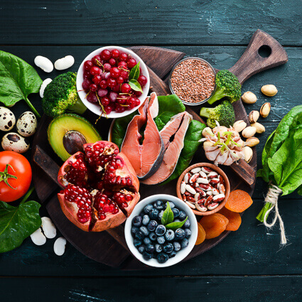 berries fish and vedgestable spread out on black table top