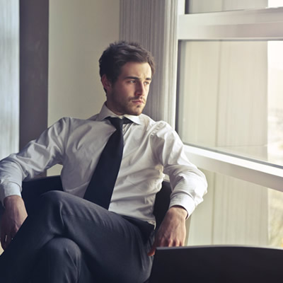 man sitting beside window looking outside