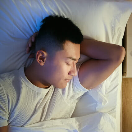 top view of man sleeping next to nightstand