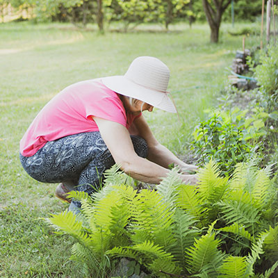 woman gardening with a wide brim hat on