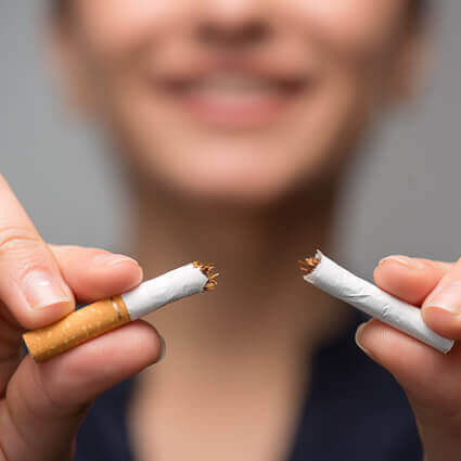 woman proudly holding broken cigarette 