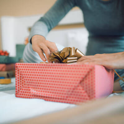 woman wrapping gifts wearing pajamas
