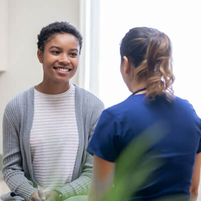 woman smiling during a consultation with a practitioner