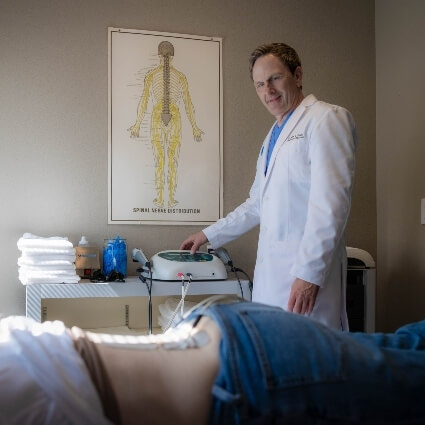 Johnston chiropractor Dr Alan during e-stim therapy on patient