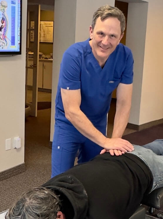 Johnston chiropractor Dr Alan using laser tool on patients arm
