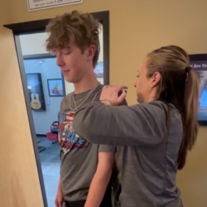 our chiropractor adjusting teen's shoulders