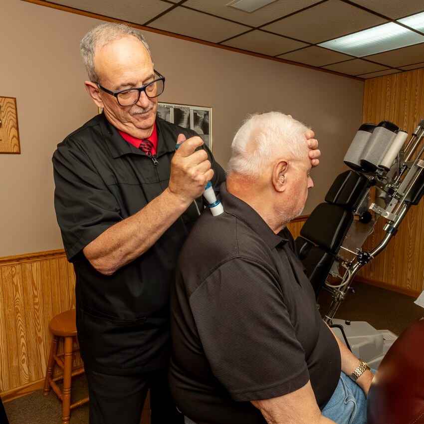 Dr D adjusting patient with tool