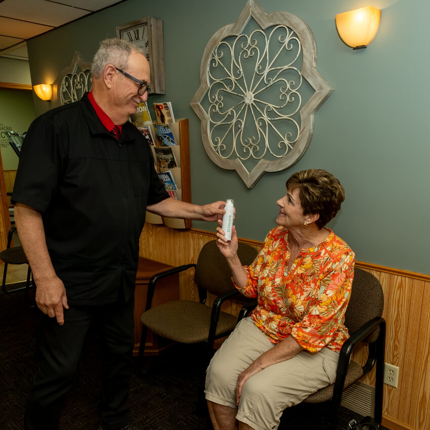 Dr D handing Hoover Chiropractic Clinic patient supplement bottle
