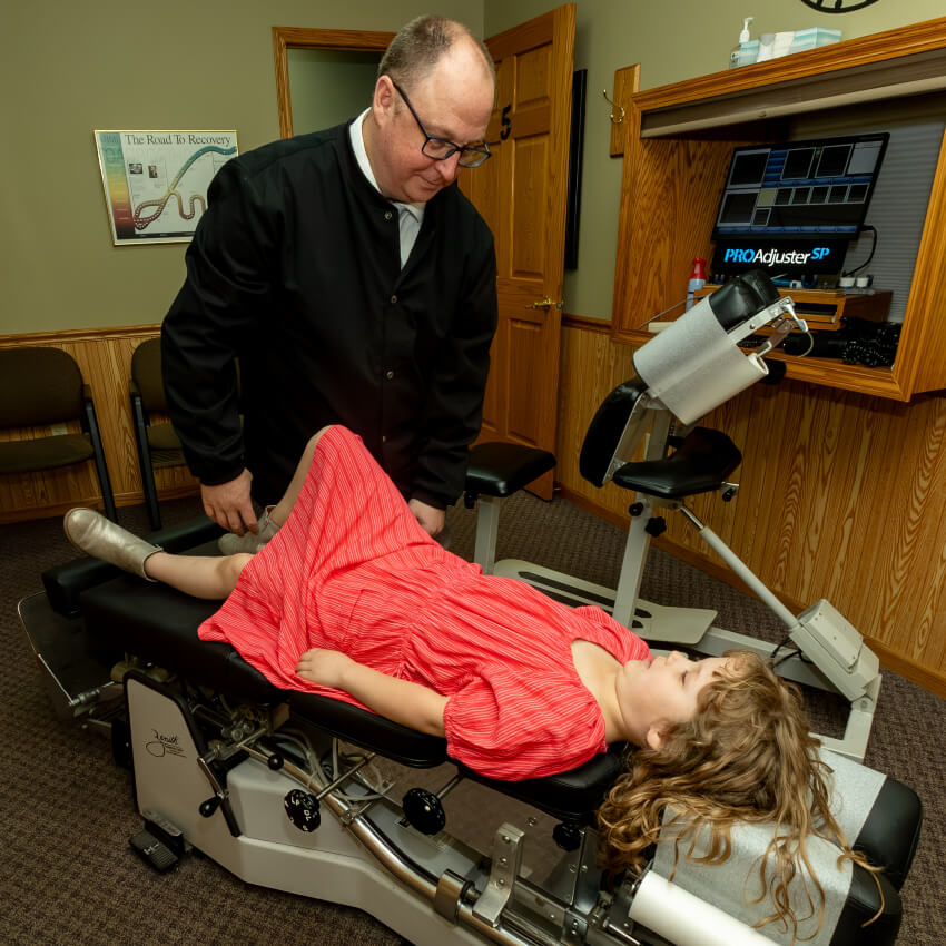 Dr M adjusting girl laying on table