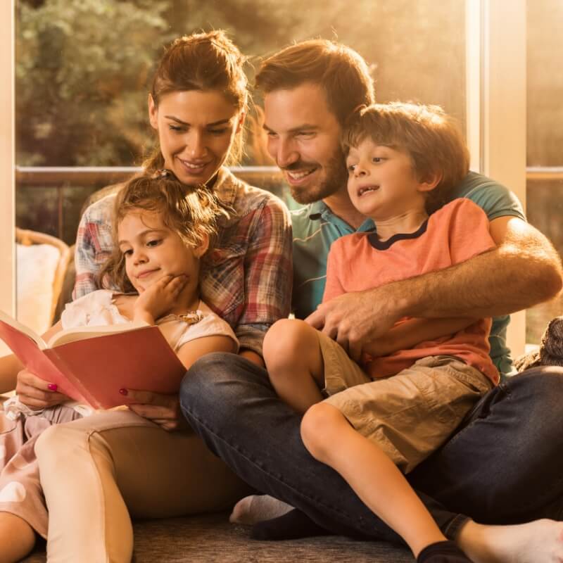Family of four reading a book