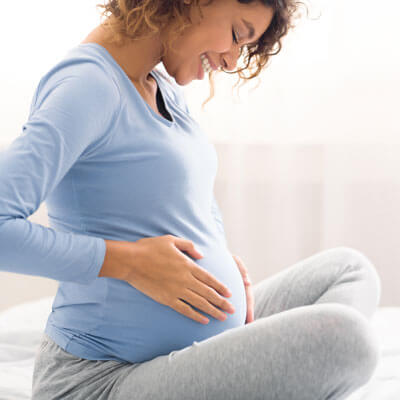 pregnant woman smiling at her belly