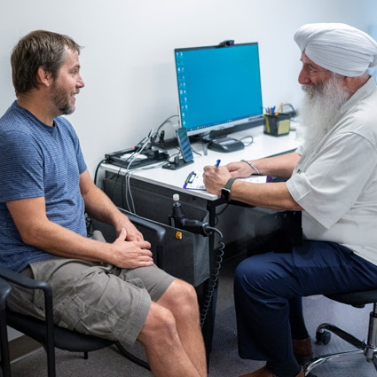 Dr. Khalsa speaking with a patient in his office