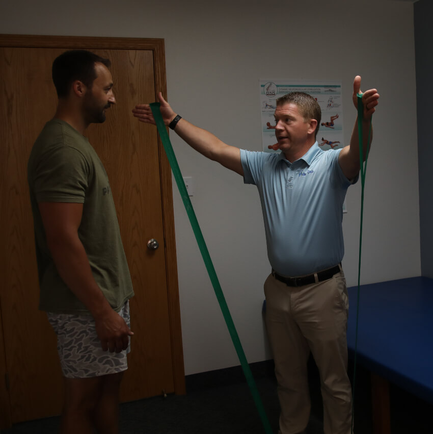 chiropractor showing patient how to use bands