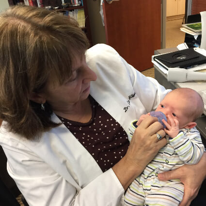 Dr. Cleo holding baby