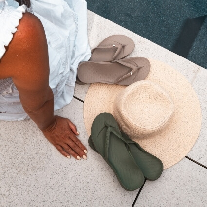 woman sitting near flip flops