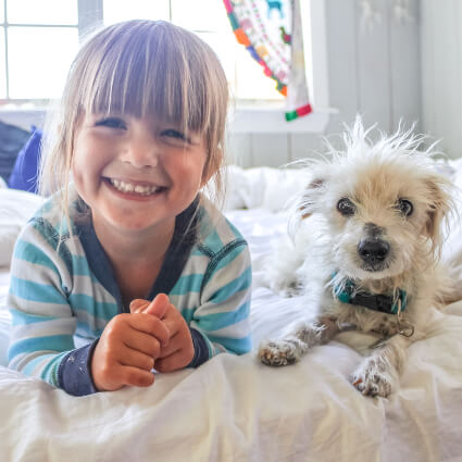 Girl and dog on bed