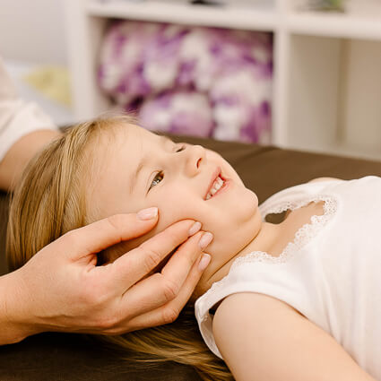 little-girl-smiling-while-chiropractor-adjusts-jaw-sq