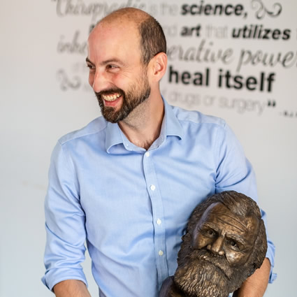 Doc smiling with sculpture