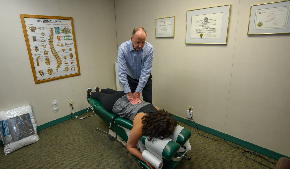 Dr. David Egan adjusting patient's back