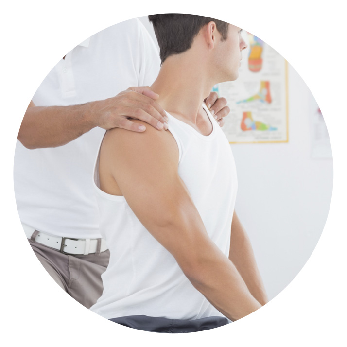 chiropractor with hands on mans shoulders
