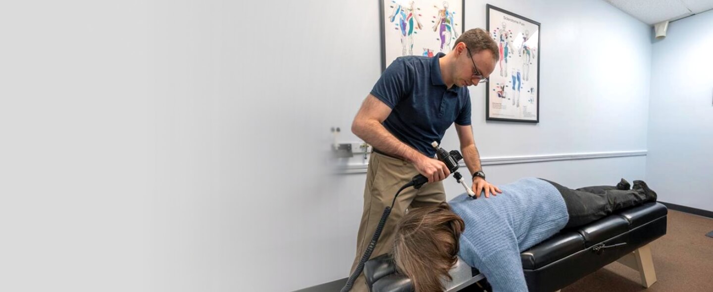 Hanover Park chiropractor Dr Muller adjusting patients back with tool