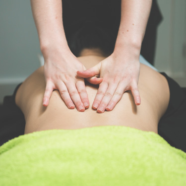 Massage therapist hands on back