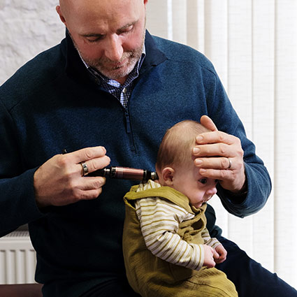 Dr Ed adjusting infant with activator tool