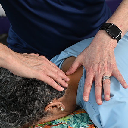 practitioner adjusting practice member's neck