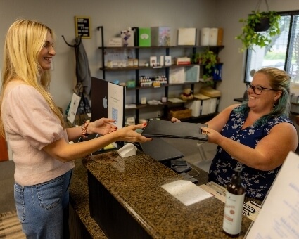 Receptionist handing over clipboard to patient