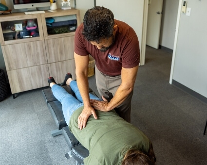 Male chiropractor adjusting female patient
